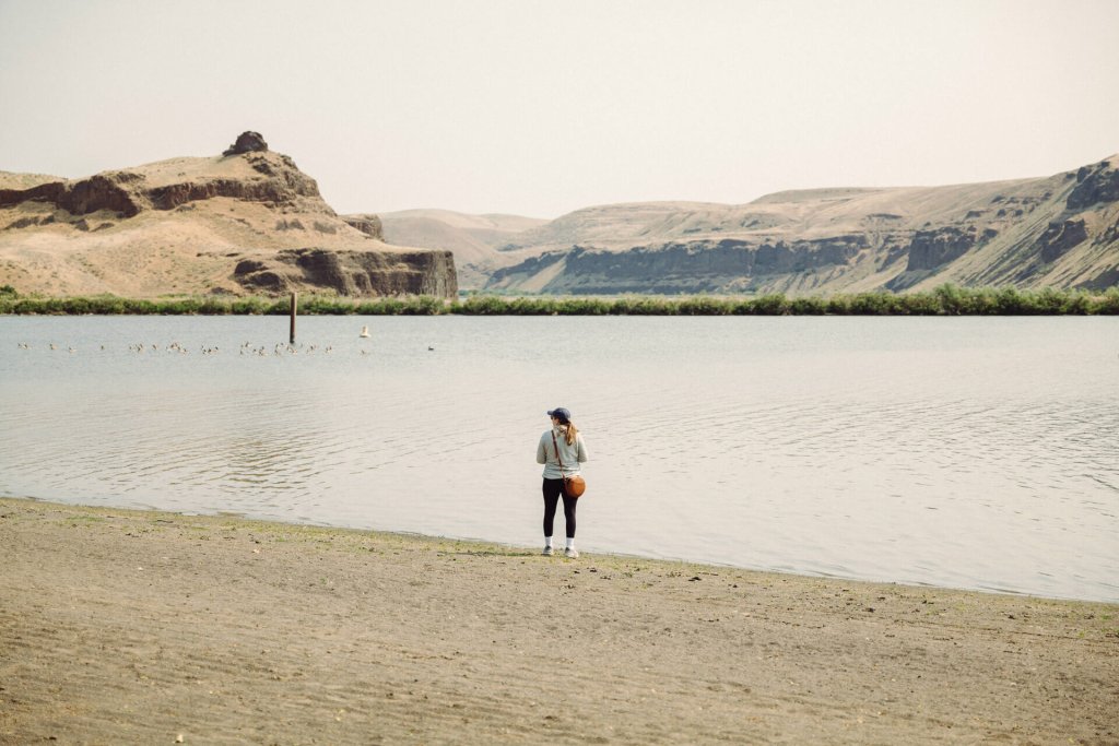 A woman stands at the edge of a river at Lyons Ferry State Park.